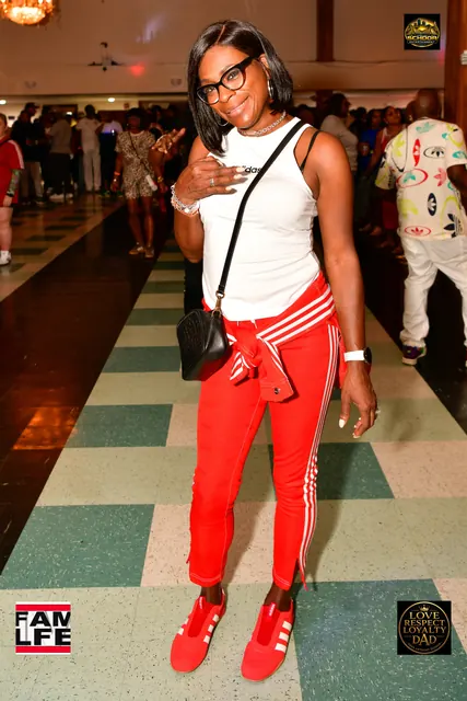 Guest in red three-stripe track pants and red sneakers