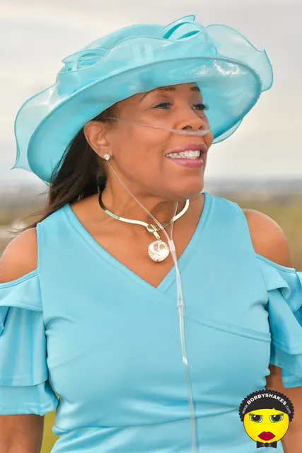 Guest in a sky-blue organza hat and ruffled blue dress