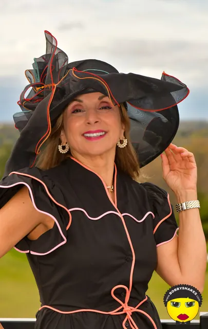 Guest in a black ruffled hat with coral trim